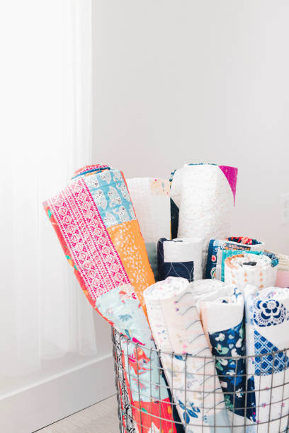 Quilts rolled up in a basket in the living room stock photo
