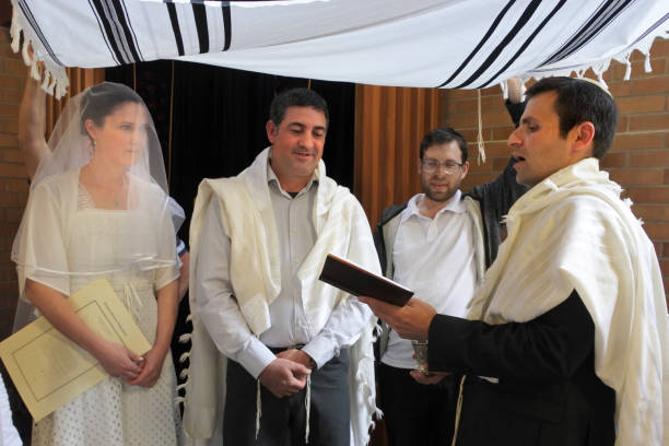Rabbi blessing Jewish bride and a bridegroom in Jewish wedding ceremony Rabbi blessing Jewish bride and a bridegroom in modern Orthodox Jewish wedding ceremony in synagog. ketubah stock pictures, royalty-free photos & images