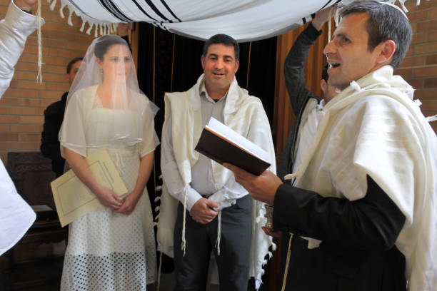 Rabbi blessing Jewish bride and a bridegroom in Jewish wedding ceremony Rabbi blessing Jewish bride and a bridegroom in modern Orthodox Jewish wedding ceremony in synagogue.Real people. Copy space ketubah stock pictures, royalty-free photos & images