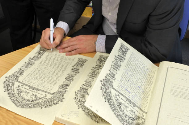 Rabbi signing Ketubah Jewish Prenuptial Agreement AUCKLAND  - OCT 31 2018:Rabbi signing Ketubah Jewish Prenuptial Agreement document in a traditional Jewish marriage that outlines the rights and responsibilities of the groom, in relation to the bride. ketubah stock pictures, royalty-free photos & images