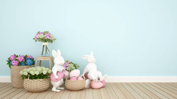 Rabbit puppets hold eggs and sit on eggs in a light blue room decorated with colorful flowers. 3D illustration for Easter day artwork.  easter sunday stock pictures, royalty-free photos & images