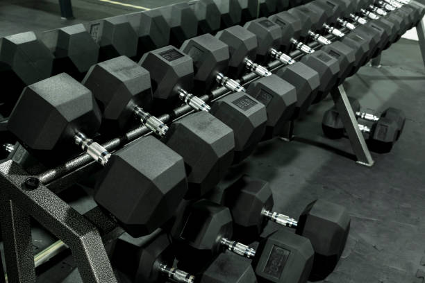 A rack of heavy hex dumbbells at a gym or fitness club. Workout and pyramid training or running the rack for serious bodybuilding concept. stock photo