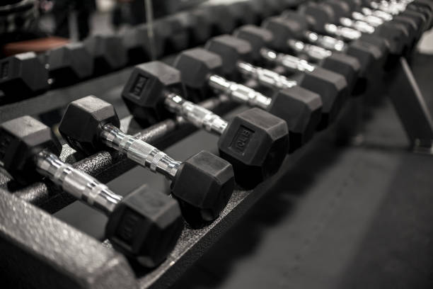 A rack of rubberized hex dumbbells at a gym or fitness club. Workout and pyramid training or running the rack concept. stock photo