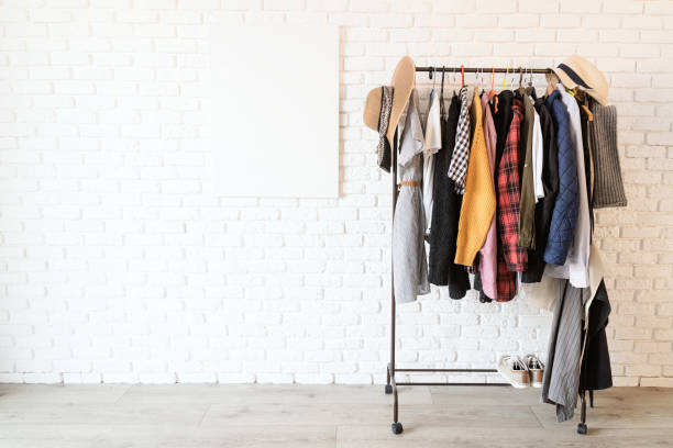 Rack with colorful clothes on hangers and frame canvas for mock up over white brick wall background Rack with colorful clothes on hangers and frame canvas for mock up over white brick wall. Mock up design clothing store photos stock pictures, royalty-free photos & images