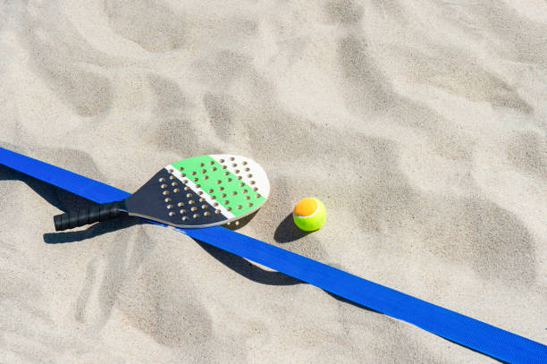 raquete e bola na praia de areia. conceito de esporte de verão - beach tennis - fotografias e filmes do acervo