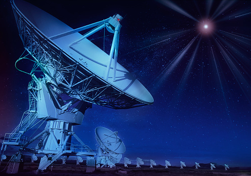 Night shot of radar telescopes with starburst