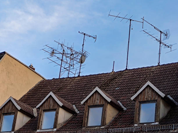 Radio and television antennas on a house roof stock photo