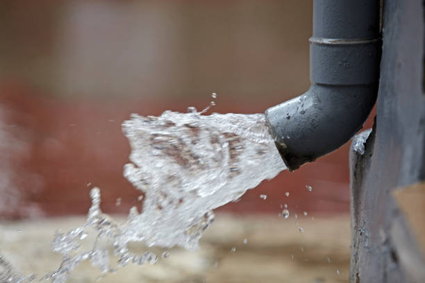 Rain water flowing from plastic gutter. stock photo
