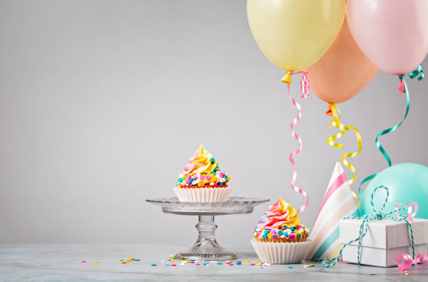 Rainbow Birthday Cupcakes with Balloons stock photo