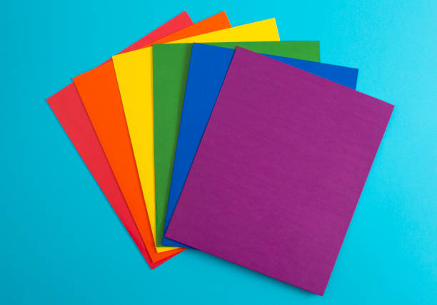 Rainbow Folders of School or Office Supplies on a Bright Blue Background stock photo