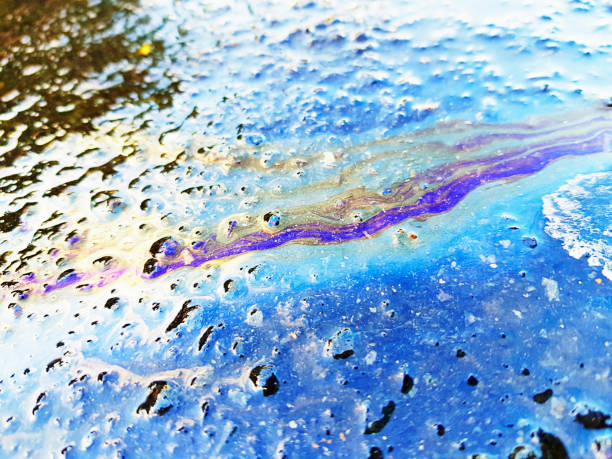 Rainbow oil slick on rainy road Oil on a rainy street produces a colorful spectrum. contamination stock pictures, royalty-free photos & images