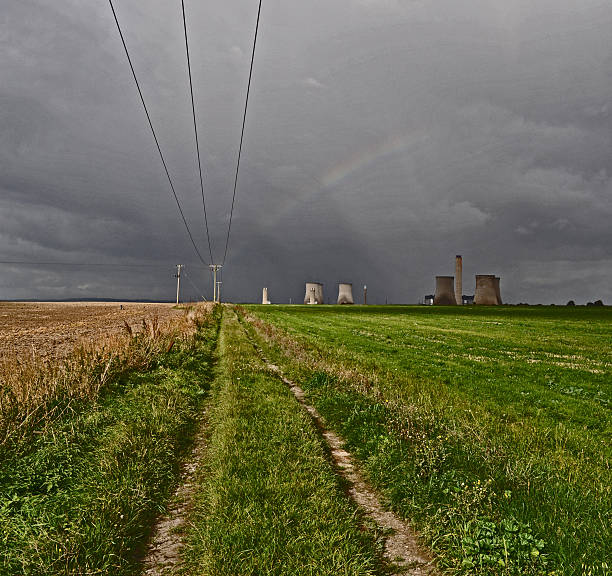 Rainbow over Didcot Power Station Taken near the Didcot power station overlooking a filed with grass and crops, with overhead power lines showing a rainbow over the power station. normalisaverage stock pictures, royalty-free photos & images