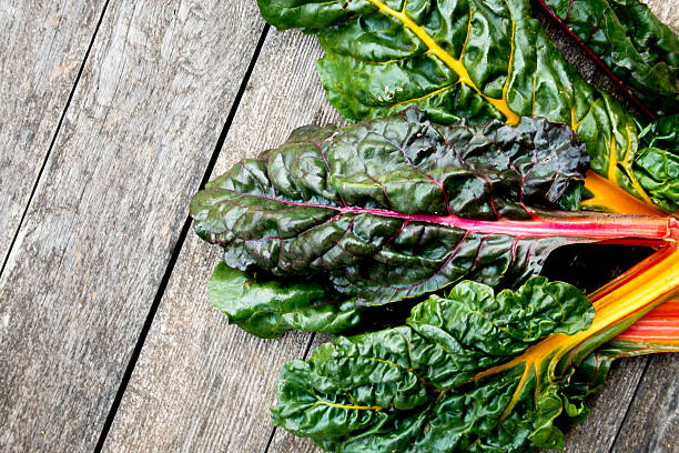 Rainbow Swiss Chard Rainbow Swiss Chard on weathered picnic table chard stock pictures, royalty-free photos & images