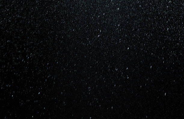 Raindrops falling down on black background stock photo