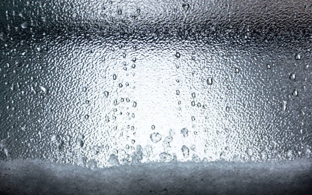 Raindrops on a Frosted Window with Snow stock photo