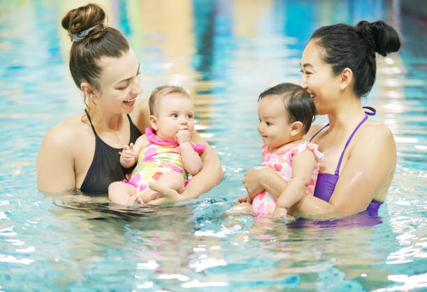 het verhogen van hun kleintjes met een belangrijke levens vaardigheid - swimming baby stockfoto's en -beelden