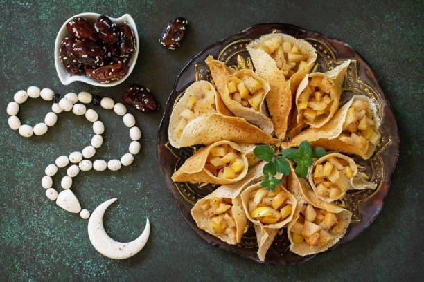 Ramadan kareem festive, fasting, halal food. Ramadan menu, arabian pancake katayef (katayev, qatayef) with apple filling and cinnamon. Top view, flat lay. stock photo
