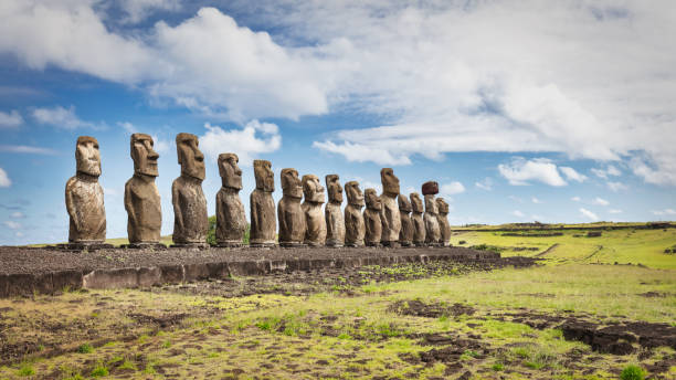 Rapa Nui Ahu Tongariki Moai Statues Panorama Easter Island Chile Easter Island Ahu Tongariki Panorama. Fifteen ancient civilization polynesian Moai Statues standing side by side in a row along the pacific ocean coast under sunny blue summer sky with fluffy cloudscape. Rapa Nui. Easter Island, Isla de Pascua, Polynesia, Chile, Oceania unesco world heritage site stock pictures, royalty-free photos & images