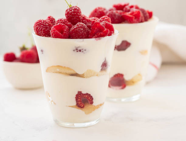 Raspberry dessert, cheesecake, raspberry tiramisu, trifle, mousse in a glass on a white background. stock photo