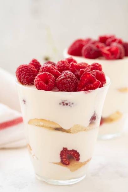 Raspberry dessert, cheesecake, raspberry tiramisu, trifle, mousse in a glass on a white background. stock photo