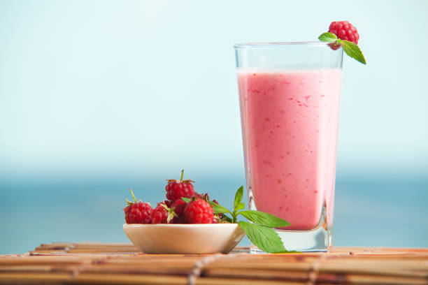 Raspberry milkshake with mint with sea on the background. stock photo