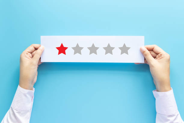rating and feedback concept. customer holding paper with poor satisfied review by give one star for service experience stock photo