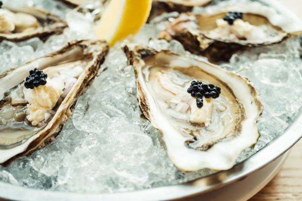 Raw and fresh Oyster with caviar on top and lemon stock photo