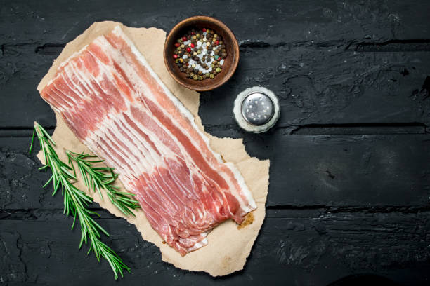 Raw bacon with rosemary and spices. stock photo