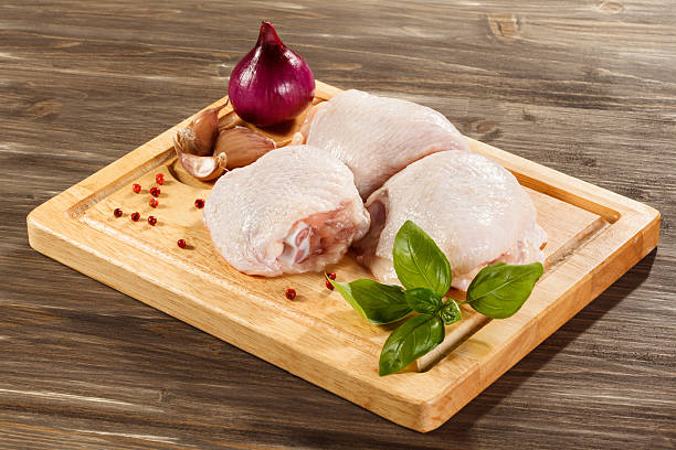 Raw chicken legs on cutting board stock photo