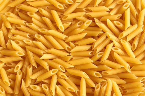Raw farfalle pasta background Raw farfalle pasta background macaroni stock pictures, royalty-free photos & images