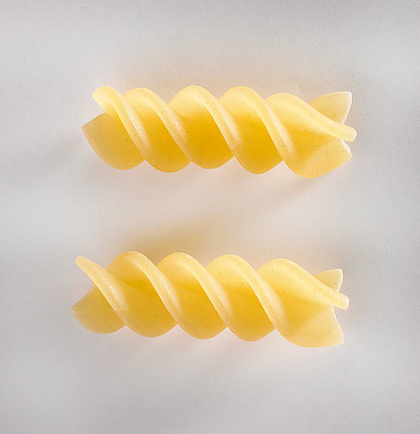 raw fusilli pasta pasta cruda fusilli su fondo bianco uncooked pasta stock pictures, royalty-free photos & images