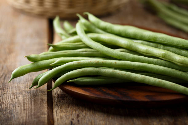 Raw green beans Raw green beans on wooden desk green bean stock pictures, royalty-free photos & images