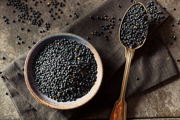 Raw Organic Black Lentils Raw Organic Black Lentils in a Bowl beluga whale stock pictures, royalty-free photos & images