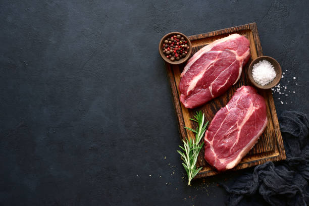Raw organic marbled beef steaks with spices stock photo