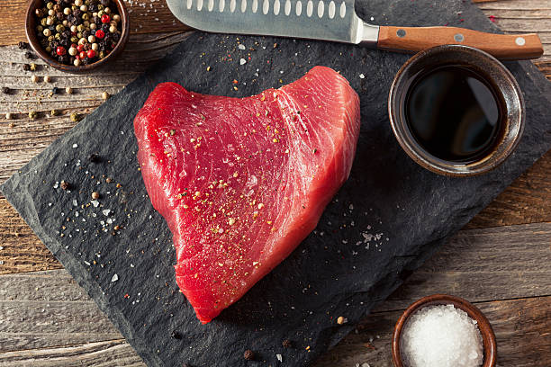 bistecca di tonno rosa biologico crudo - tonno frutto di mare foto e immagini stock