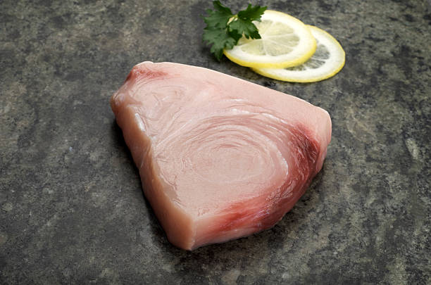 Raw Swordfish Steak on Granite with Lemon stock photo