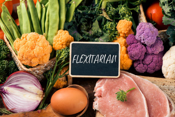 raw vegetables, eggs and meat and text flexitarian stock photo