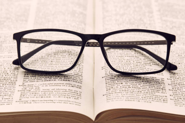 Reading glasses on a book stock photo