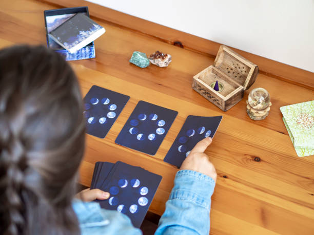 reading moon tarot cards for herself at home with a magical atmosphere stock photo