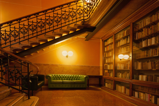 Reading Room with Sofa, Bookshelf and Staircase, Milan, Italy.