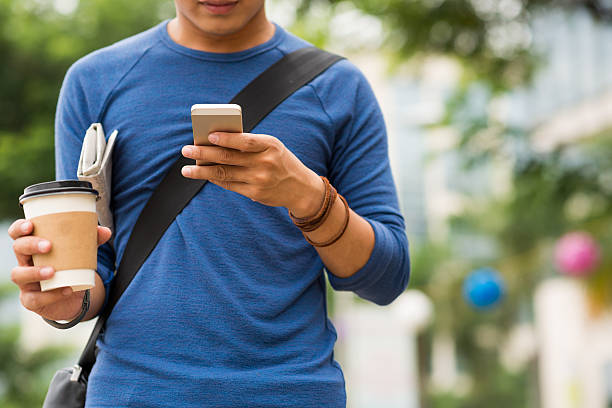 reading text message - walking with coffee stockfoto's en -beelden