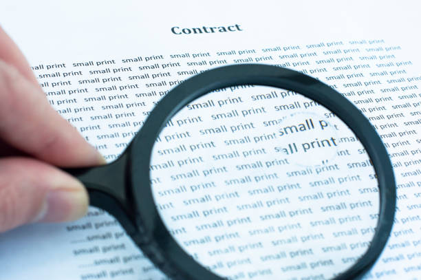 Reading the small print Reading the small print of a contract. loophole stock pictures, royalty-free photos & images