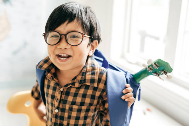 Ready for school Smiling boy with backpack and favourite guitar boys glasses stock pictures, royalty-free photos & images