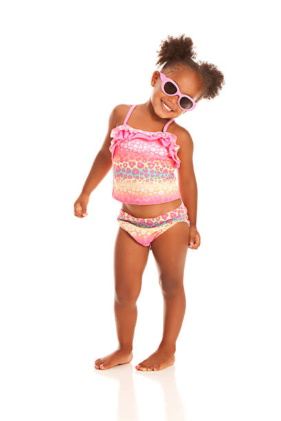 Ready for the Beach Adorable little girl in sunglasses and a bathing suit. Isolated on white. little girls in bathing suits stock pictures, royalty-free photos & images