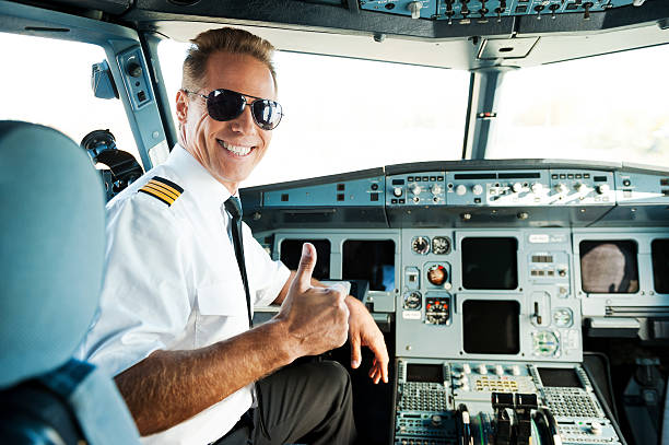 Ready to flight. Rear view of confident male pilot showing his thumb up and smiling while sitting in cockpit pilot stock pictures, royalty-free photos & images