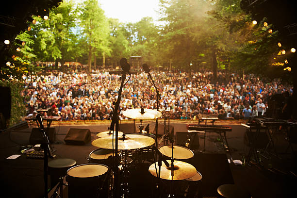 Ready to go on stage Shot of musical instruments on a stage looking out over a huge crowd amphitheater stock pictures, royalty-free photos & images