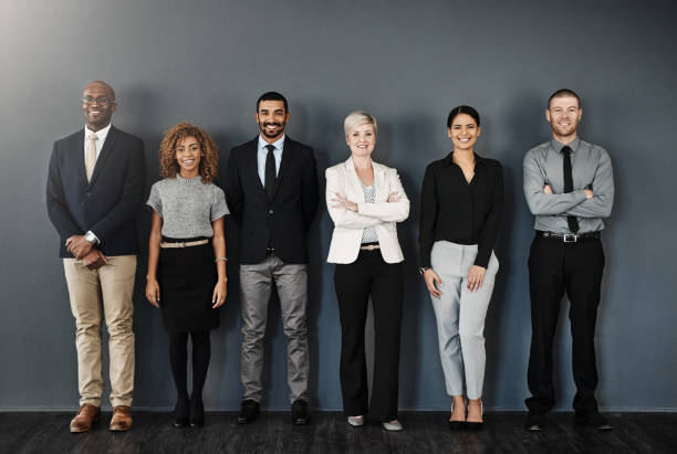 Ready to make success happen Studio portrait of a group of businesspeople posing against a dark background waiting in line photos stock pictures, royalty-free photos & images