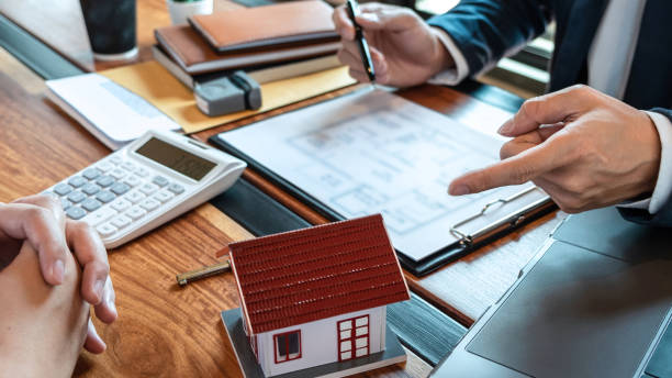 Real estate agent are presenting home loan and sending keys to customer after signing contract to buy house with approved property application form, Insurance Home concept stock photo