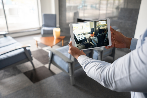Real Estate Agent showing a property through an online video call using a tablet computer - real estate concepts