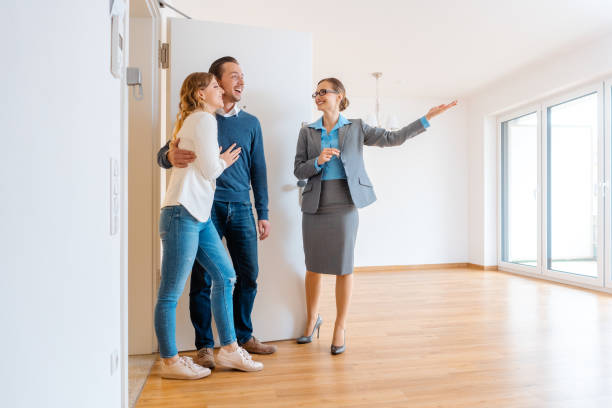 Real Estate Agent showing house to a young couple Real Estate Agent showing house to a young couple wanting to rent it real estate agent stock pictures, royalty-free photos & images